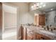 Bathroom with dual sinks, granite countertops, and a large mirror at 18720 Lake Dr, Monument, CO 80132