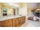 This bathroom has wood cabinets, a granite countertop, a large mirror, and is adjacent to the bedroom and closet at 18720 Lake Dr, Monument, CO 80132