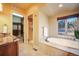 An elegant bathroom features a soaking tub, a glass enclosed shower, a closet, and granite countertops at 18720 Lake Dr, Monument, CO 80132