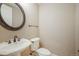 Powder room with pedestal sink, decorative mirror, and standard toilet at 18720 Lake Dr, Monument, CO 80132