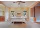 A beautiful bedroom features a ceiling fan, tray ceiling and is adjacent to a bathroom and sitting area at 18720 Lake Dr, Monument, CO 80132