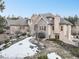 Impressive home featuring elegant architecture, mature trees, and a well-maintained yard with a touch of snow at 18720 Lake Dr, Monument, CO 80132