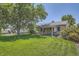Beautifully landscaped backyard with lush lawn, mature tree and covered porch, perfect for relaxation at 1140 S Xavier St, Denver, CO 80219