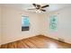 Bedroom with two windows, wood floor, ceiling fan, and white walls at 1140 S Xavier St, Denver, CO 80219
