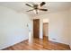 Bedroom features wood floor, ceiling fan, a door, and a view into another room at 1140 S Xavier St, Denver, CO 80219