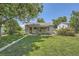 Charming home exterior with a well-maintained lawn, a cozy covered porch, and mature trees enhancing curb appeal at 1140 S Xavier St, Denver, CO 80219