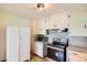 This cozy kitchen features white appliances, overhead cabinets, and neutral backsplash at 1140 S Xavier St, Denver, CO 80219