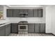 The kitchen features gray cabinets, stainless steel appliances and sleek subway tile backsplash at 965 W 96Th Ave, Thornton, CO 80260
