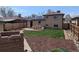Spacious backyard featuring a lush lawn, wood patio set, solar panels, and brick exterior at 3530 Dahlia St, Denver, CO 80207