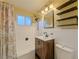 Bathroom with decorative shower curtain, stylish vanity, and a mirror with industrial shelving at 3530 Dahlia St, Denver, CO 80207