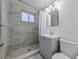 Modern bathroom featuring sleek fixtures, a shower, and tiled walls at 3530 Dahlia St, Denver, CO 80207