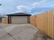 Detached garage with a concrete driveway and a newly installed wooden privacy fence at 3530 Dahlia St, Denver, CO 80207