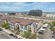 An aerial view of modern townhouses with balconies and garages against a backdrop of city buildings and mountains at 3195 Blake St # 106, Denver, CO 80205