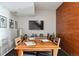 Dining area with a large wooden table, modern art, and a wall-mounted television at 3195 Blake St # 106, Denver, CO 80205