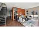 Open living area with staircase, hardwood floors, sofa and wood accent wall at 3195 Blake St # 106, Denver, CO 80205