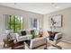 Bright living room featuring hardwood floors, large windows with leafy views, a stylish sofa, and unique artwork at 3195 Blake St # 106, Denver, CO 80205