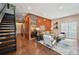 Open-concept living room showcasing a wood-paneled wall, staircase, and elegant decor at 3195 Blake St # 106, Denver, CO 80205