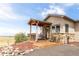 Covered porch with stone feature wall and wooden deck at 8408 Vinegarroon Rd, Parker, CO 80138