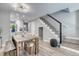 Open-concept dining area with stylish lighting, a dining table, and staircase at 1811 S Quebec Way # 103, Denver, CO 80231