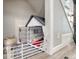 Under-stairs dog nook with a cozy bed and safety gate at 1811 S Quebec Way # 103, Denver, CO 80231