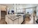 Spacious kitchen island flowing into the dining area with hardwood floors, stainless appliances, and natural light at 14147 Hudson St, Thornton, CO 80602