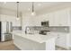 Modern kitchen featuring white cabinetry, quartz countertops, stainless steel appliances, and a stylish backsplash at 5960 S Platte Canyon Dr, Littleton, CO 80123