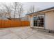 Exterior view of the concrete backyard featuring a patio and a white door with glass inserts at 1056 S Macon Way, Aurora, CO 80012