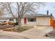 Front exterior view of a house with blue shutters, a red front door, and a long driveway at 1056 S Macon Way, Aurora, CO 80012