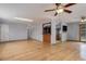Open concept living room featuring gleaming hardwood floors, a cozy fireplace, an open bar, and a view into the kitchen at 1056 S Macon Way, Aurora, CO 80012