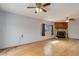 Spacious living room featuring gleaming hardwood floors, a cozy fireplace, and dual ceiling fans at 1056 S Macon Way, Aurora, CO 80012