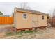 Backyard shed featuring light yellow painted wood and a crossbuck design on the door with two small windows at 1056 S Macon Way, Aurora, CO 80012
