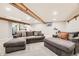 Cozy basement living area with exposed beams, recessed lighting, and comfortable gray couches at 8102 S Carr Ct, Littleton, CO 80128