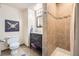 Bathroom with tiled shower, vanity, decorative mirror, and nearby toilet for convenience at 8102 S Carr Ct, Littleton, CO 80128