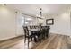 Elegant dining room featuring wood floors, a modern light fixture, and a large window at 8102 S Carr Ct, Littleton, CO 80128