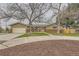 Charming single-story home with a well-manicured lawn, large trees, and a welcoming front porch at 8102 S Carr Ct, Littleton, CO 80128