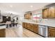 Bright, open kitchen featuring wood cabinets, stainless steel appliances, and a view of the dining area at 8102 S Carr Ct, Littleton, CO 80128