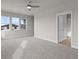 Spacious carpeted bedroom featuring large windows and modern ceiling fan at 21202 E 63Rd Dr, Aurora, CO 80019