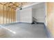 Spacious unfinished garage with drywall, exposed rafters and stairs at 21202 E 63Rd Dr, Aurora, CO 80019