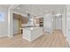 Open concept kitchen with island, stainless appliances, and wood laminate flooring at 21202 E 63Rd Dr, Aurora, CO 80019