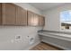 A clean laundry room with counterspace, upper cabinets, and wood floors at 21202 E 63Rd Dr, Aurora, CO 80019