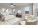 Bright primary bedroom featuring a ceiling fan, modern furnishings, and large windows, carpeted floors, and natural light at 21202 E 63Rd Dr, Aurora, CO 80019