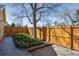 Backyard features a wood fence, stone pathway, a tree, and bushes at 7641 S Rosemary Cir, Centennial, CO 80112