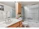 Bathroom featuring a marble countertop, wooden cabinets, and shower with glass doors at 7641 S Rosemary Cir, Centennial, CO 80112