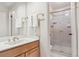 Bathroom featuring a wooden vanity with gold fixtures and a shower with glass doors at 7641 S Rosemary Cir, Centennial, CO 80112