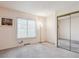 Bedroom with carpet, a window with blinds, and mirrored closet doors at 7641 S Rosemary Cir, Centennial, CO 80112