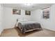 Bedroom features neutral carpet, one window, and two art pieces above the bed at 7641 S Rosemary Cir, Centennial, CO 80112