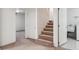 Hallway with carpeted stairs, a washing machine, and access to other rooms at 7641 S Rosemary Cir, Centennial, CO 80112