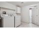 Laundry room features a washer, dryer, overhead cabinets and tiled floors at 7641 S Rosemary Cir, Centennial, CO 80112