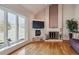 Bright living room featuring a fireplace, a large window with views, and hardwood flooring at 7641 S Rosemary Cir, Centennial, CO 80112