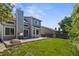 A backyard featuring a well-maintained lawn, a concrete patio, and mature trees, perfect for outdoor entertaining at 14185 W Warren Cir, Lakewood, CO 80228